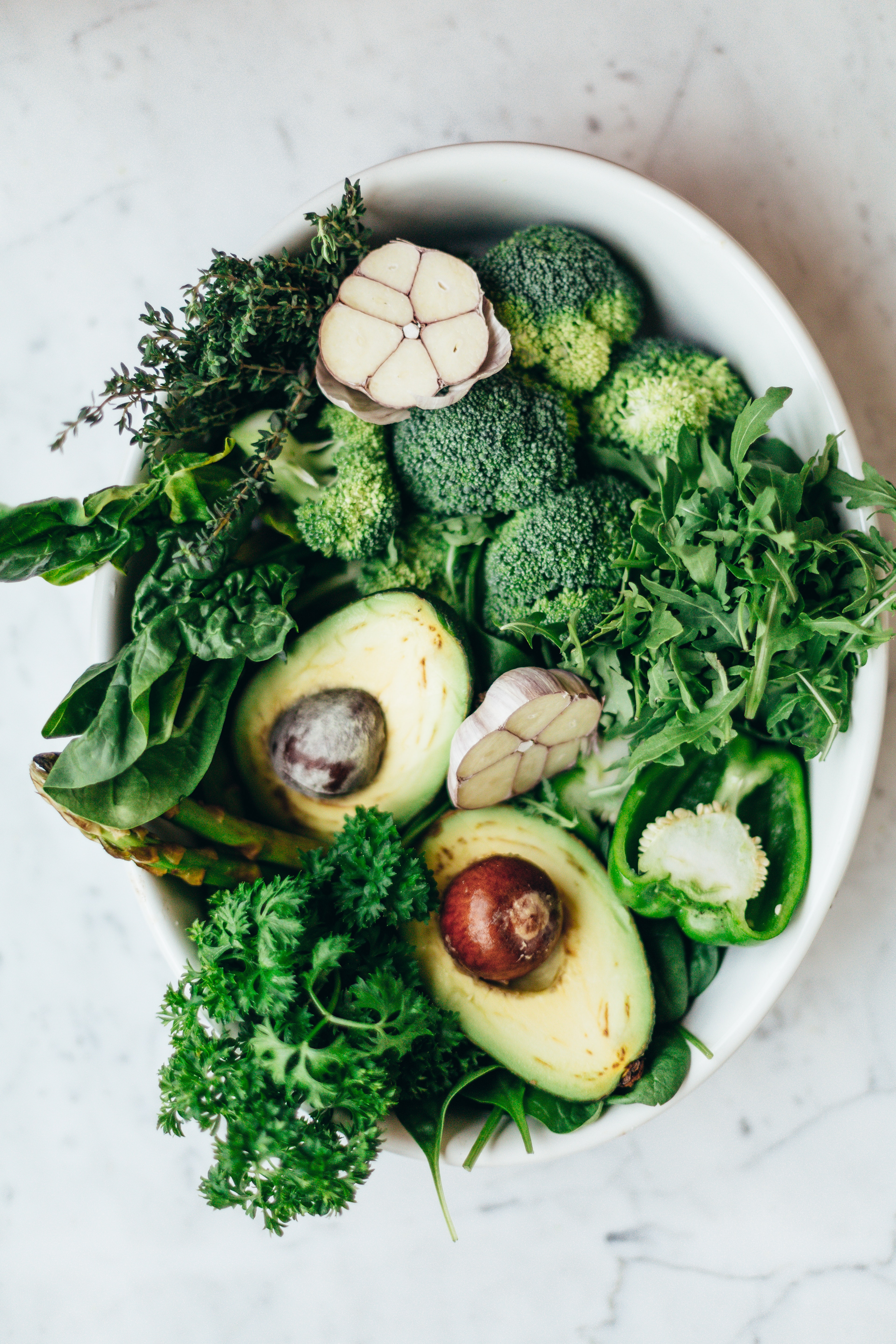 Photo of a salad with lettuce, avocados, broccoli, and mushrooms